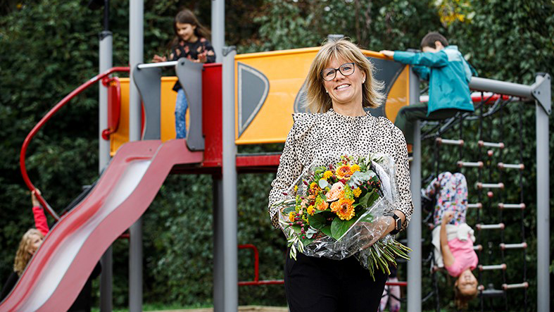 Förstelärare Ida Prisell på Haganässkolans lekplats med diplom och blombukett